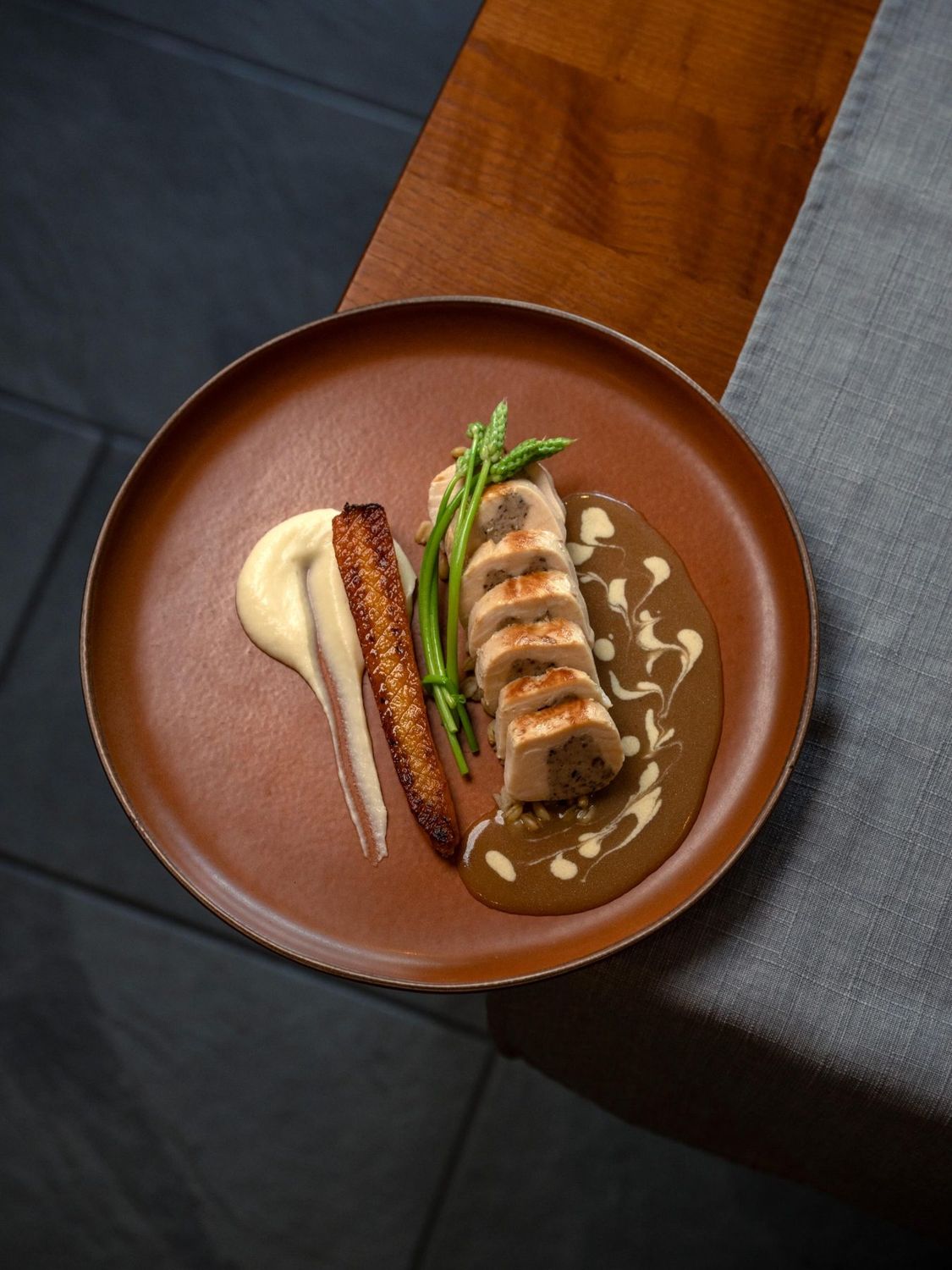 Viande et légumes glacés avec leur jus, sur une assiette terracotta