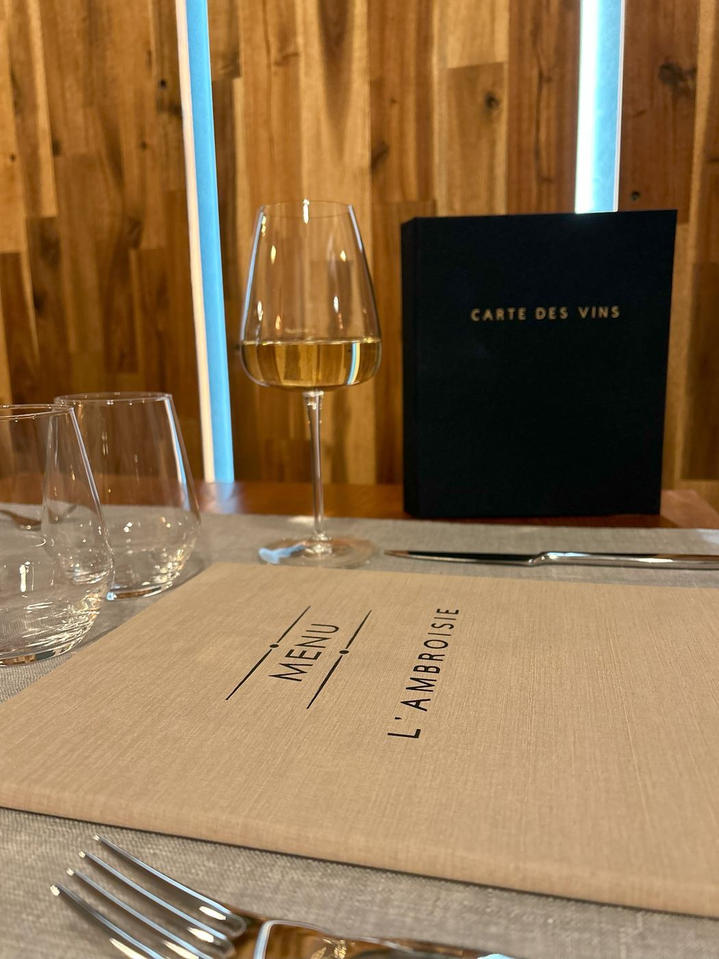 La carte du menu L'Ambroisie et la carte des vins posées sur une table dressée